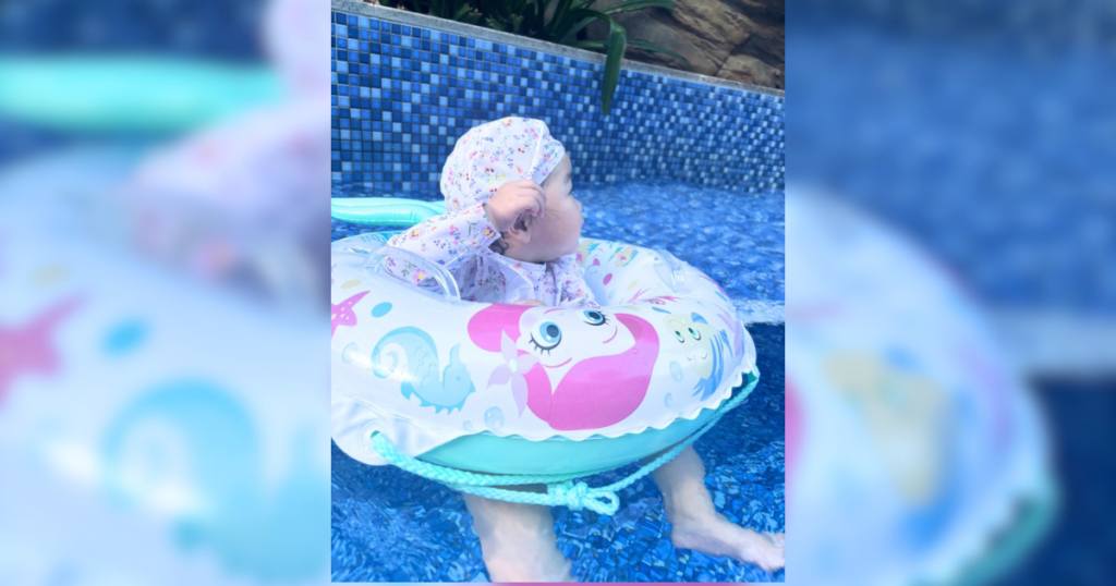 プールの浮き輪に乗る0歳の赤ちゃん