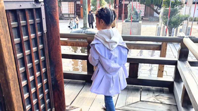 撮影を終えて疲れ、普段着で祈祷を受ける七五三の女の子