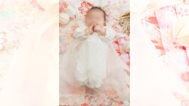 お宮参りのセレモニードレスを着た0歳の赤ちゃん